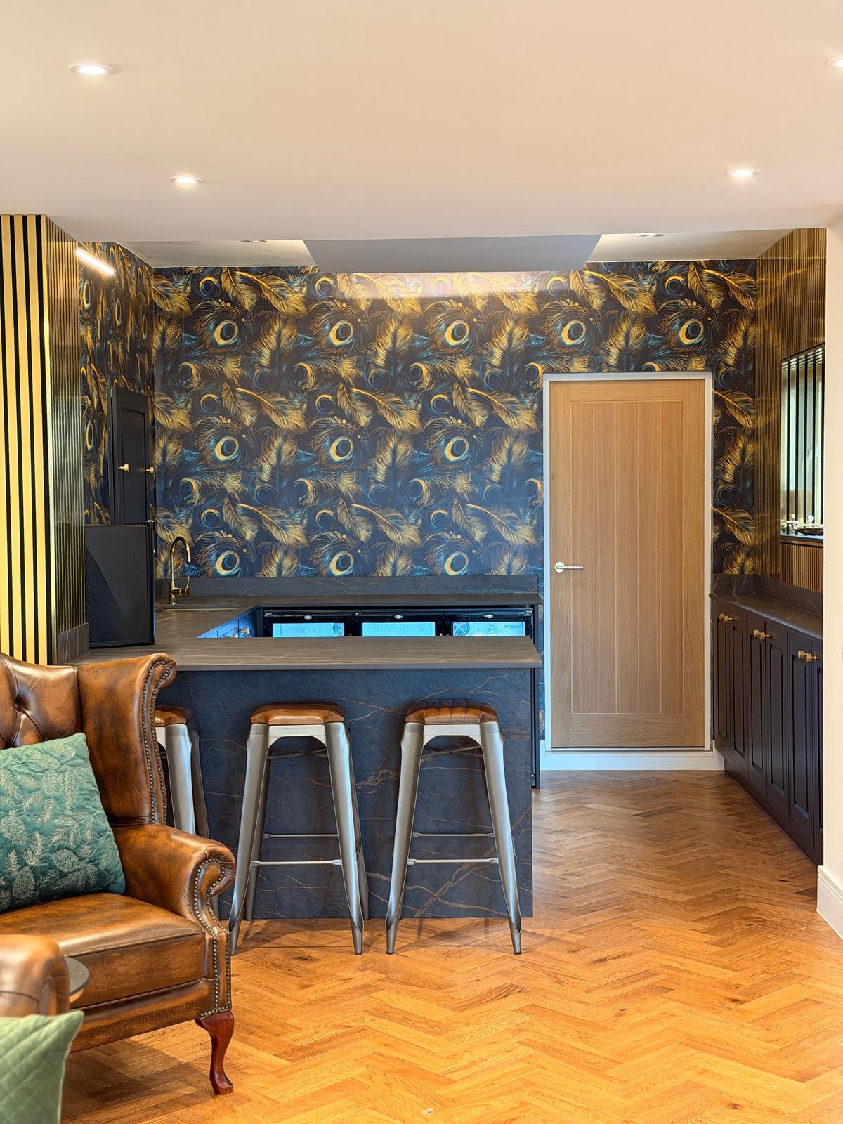 Home bar with a navy shaker back run, dark stone-effect peninsula and bar stools