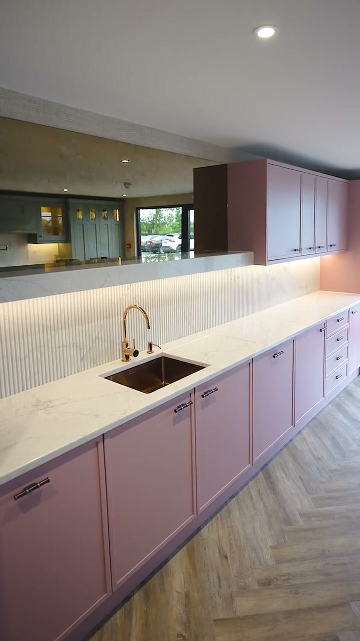 A painted kitchen in the CEK showroom with a copper sink and marble-effect worktop